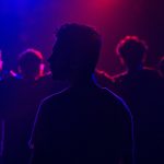 a-group-of-people-in-a-dark-room-with-bright-lights-h7zpyrrr6g4